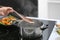 Woman boiling rice in kitchen