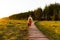 Woman botanist with backpack on ecological hiking trail in summer outdoors. Naturalist exploring wildlife and ecotourism