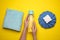 Woman with bottle of water, cold compress and towel on yellow background, top view. Heat stroke treatment