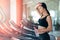 Woman with bottle of water exercising on treadmill in gym