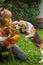 Woman with a bouquet of flowers while a beagle dog sniffs them