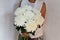 Woman with bouquet of white chrysanthemums. Beautiful fresh white flowers for holiday. Woman holding beautiful white flowers