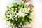 Woman with bouquet of white lilies. Beautiful fresh delicate flowers for holiday. Woman with beautiful flowers in her hands