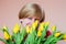 Woman with bouquet of yellow tulips mysteriously smiling, birth