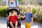 Woman with a boy and a disabled girl in a wheelchair walking in the Park summer. Child cerebral palsy. Family with disabled kid