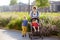 Woman with a boy and a disabled girl in a wheelchair walking in the park at summer. Child cerebral palsy. Family with disabled kid