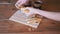 Woman breaks fresh crispy pastries with her hands over the table. Close-up.