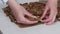 A woman breaks a walnut kozinak. Sunflower seeds, peanuts and walnuts roasted in sugar and honey. Close-up