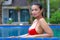 Woman breast portrait with red bikini at swimming pool