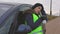 Woman breathe into paper bag near car on road in winter