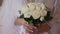 Woman bride holding roses bouquet in hands. Female in morning wearing robe preparing for the wedding