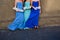 Woman bride maids in colorful blue dresses hold up a sign. Smile, love and dream