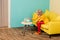 woman in bright retro clothing looking at aquarium fish while resting on sofa at colorful apartment, doll