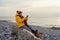 Woman in bright yellow jacket walking alone on seaside on cold winter day. Travel  Lifestyle concept