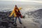 Woman in bright yellow jacket walking alone on seaside on cold winter day. Travel  Lifestyle concept