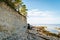 Woman with brown curly hair hiking by the Panga cliff in Saaremaa, Estonia during sunny day. The highest bedrock outcrop in