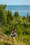 Woman with brown curly hair hiking and taking pictures with phone on the seaside by the Uugu cliff on the Muhu Island near