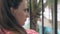 Woman with brown hair in earrings blinks and talks closeup