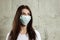 Woman with brown hair and a medical mask for protection again influenza. Shallow depth of field. Copy space for your text