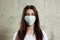 Woman with brown hair and a medical mask for protection again influenza. Shallow depth of field. Copy space for your text