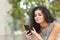 Woman is browsing smart phone content in a park