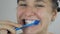 A woman is brushing her teeth in front of the mirror.Dental health. Beautiful woman brushing her teeth in the bathroom