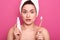 Woman brushing her teeth with shocked facial expression, girl with toothbrush  on pink studio background, lady with white