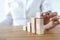 Woman build tower from wooden cubes on table close-up.