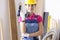 Woman builder in overalls and protective helmet holding drill in hands in workshop