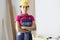 Woman builder in protective helmet standing in workshop