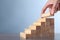 Woman building steps with wooden blocks at table, closeup. Career ladder