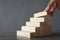 Woman building steps with wooden blocks on table, closeup. Career ladder