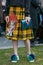Woman with Bulgari blue bag and yellow tartan skirt before Emporio Armani fashion show, Milan Fashion Week