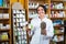 Woman with bunch of dried herbs in drugstore