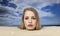 Woman buried in sand on beach