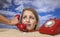 Woman buried in sand on beach with telephone