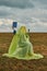 Woman in burqa on chair in field with white rose in her hands is reading book. concept