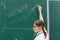 Woman business coach in a white blouse and glasses at the chalkboard in the office draws a profit graph. close-up