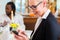 Woman on business lunch checking mails on phone