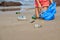 Woman busy collecting rubbish, holds garbage bag