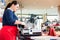 Woman in butcher shop cutting bacon with machine