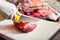 Woman in butcher shop selling meat fillet