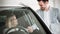 Woman buying a car in dealership sitting in her new auto