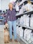 Woman buying pet food for Afghan Shepherd puppy in shop for animal