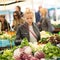 Woman buying vegetable at local food market.