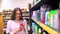 Woman buys shampoo in a supermarket