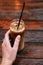 A woman in a cafe drinks a cold cappuccino. hand holds a straw in a glass with coffee. summer cool drinks