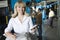 Woman With Calculator Checking Newspaper In Factory