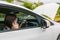 Woman calling emergency service with her broken car.