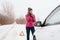 Woman calling for help or assistance - winter car breakdown